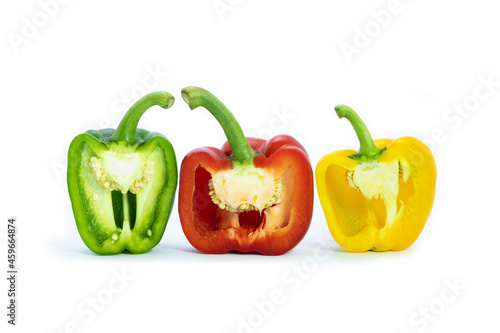 Three bell peppers, cut in half. Bell pepers is red, green and yellow on white background. Colorful vegetables.