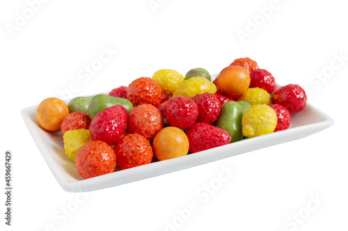 Chewing colorful gum in the form of fruit on a plate isolated on white background. Close up