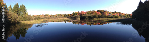 Panoramic view of a lake and forest in early autumn