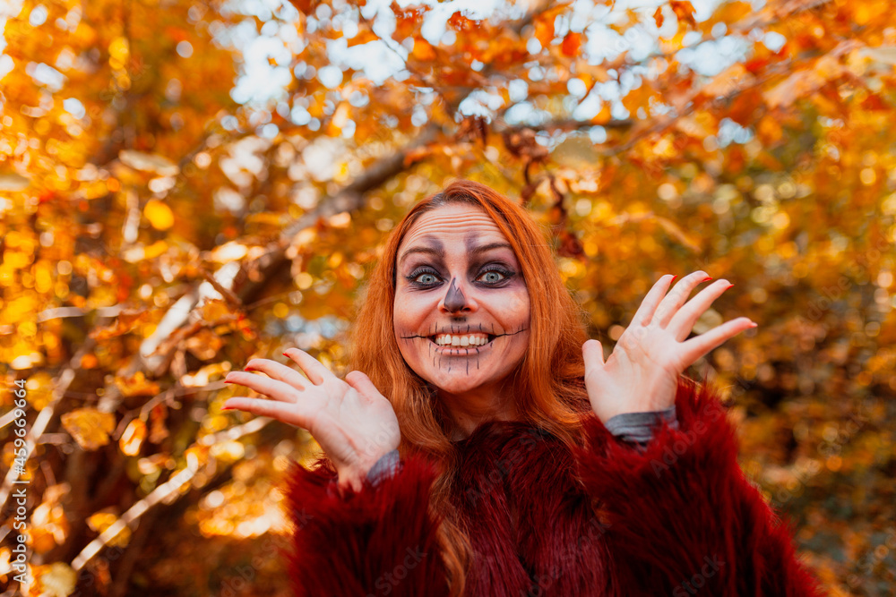 Excited woman with Halloween make-up at forest during autumn Excited woman with Halloween make-up at forest during autumn