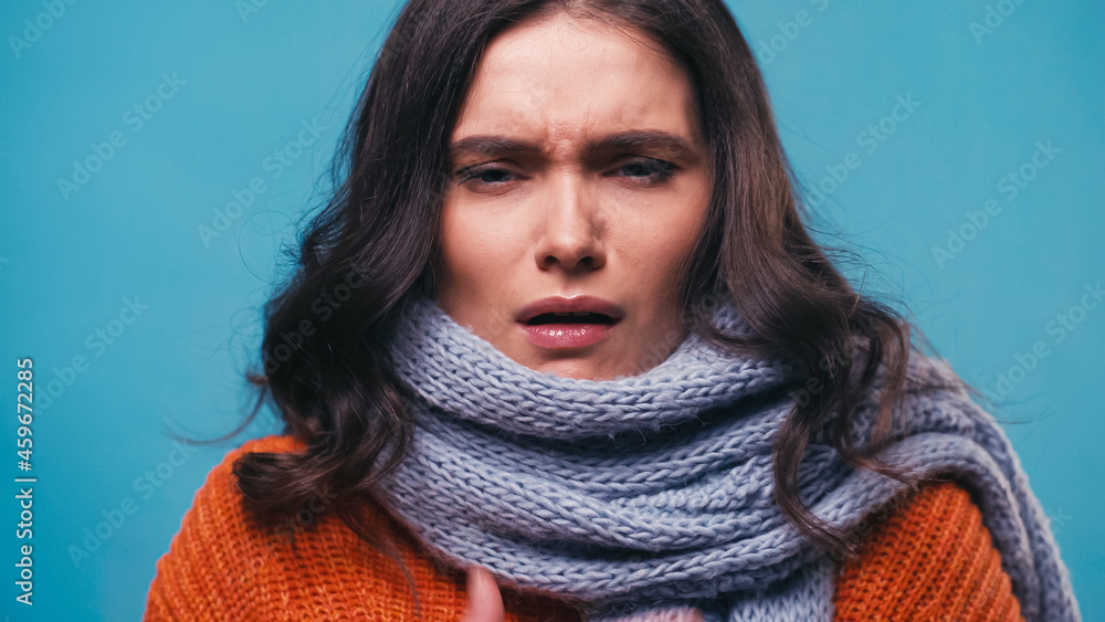 sick woman in warm scarf suffering from pain in sore throat isolated on blue sick woman in warm scarf suffering from pain in sore throat isolated on blue
