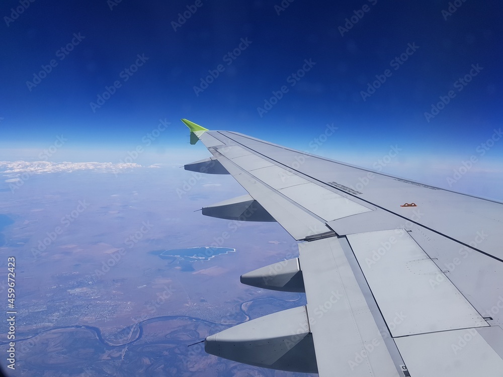 The wing of the plane is visible in the window The wing of the plane is visible in the window