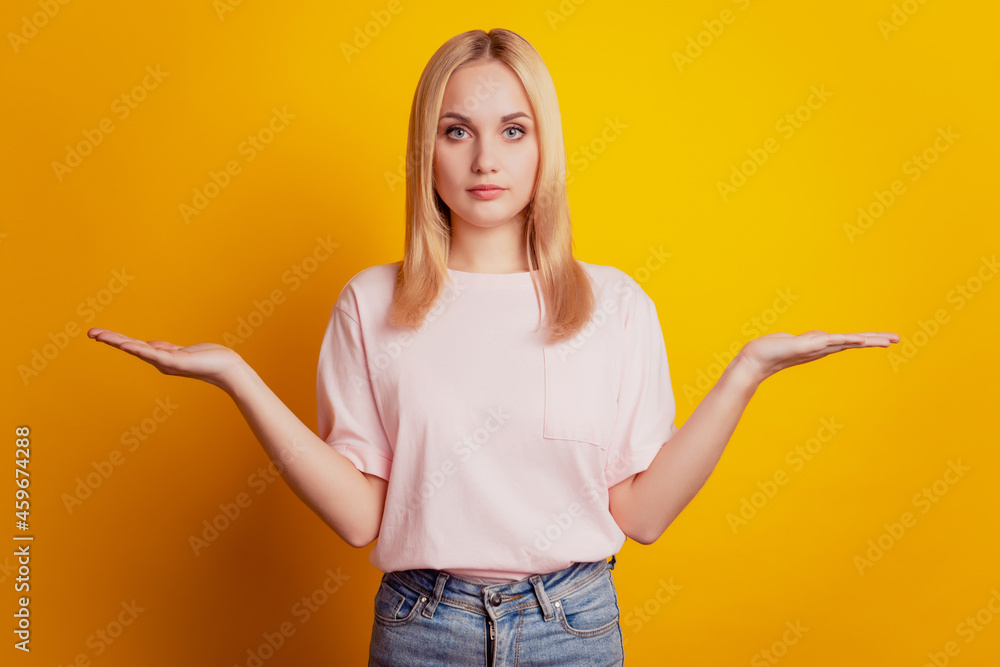 Portrait of adviser girl hands hold compare blank space on yellow background Portrait of adviser girl hands hold compare blank space on yellow background