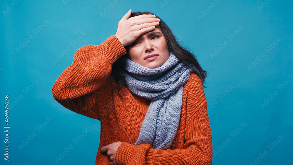 thick and displeased woman in warm jumper touching forehead isolated on blue thick and displeased woman in warm jumper touching forehead isolated on blue