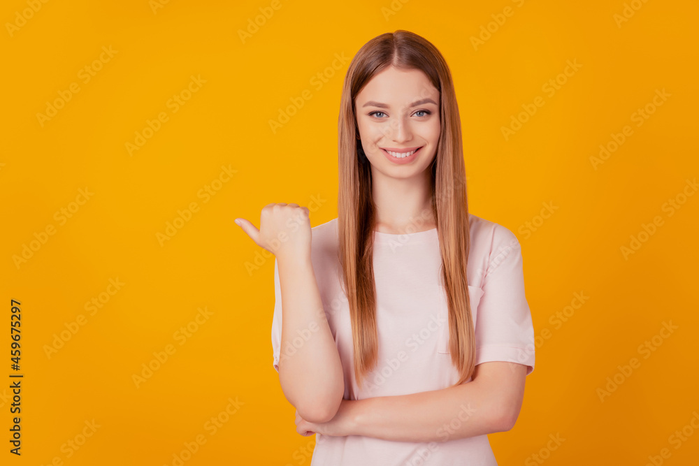 Portrait of cheerful nice lady thumb direct away show blank space on yellow background Portrait of cheerful nice lady thumb direct away show blank space on yellow background