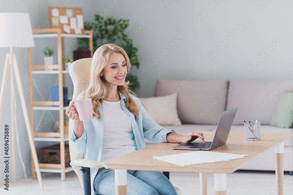 Photo portrait woman smiling drinking coffee working on laptop remotely browsing internet Photo portrait woman smiling drinking coffee working on laptop remotely browsing internet