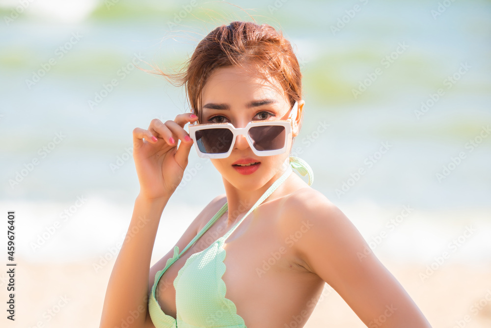 Young pretty sexy asian woman in bikini on tropical beach. summer vacation.