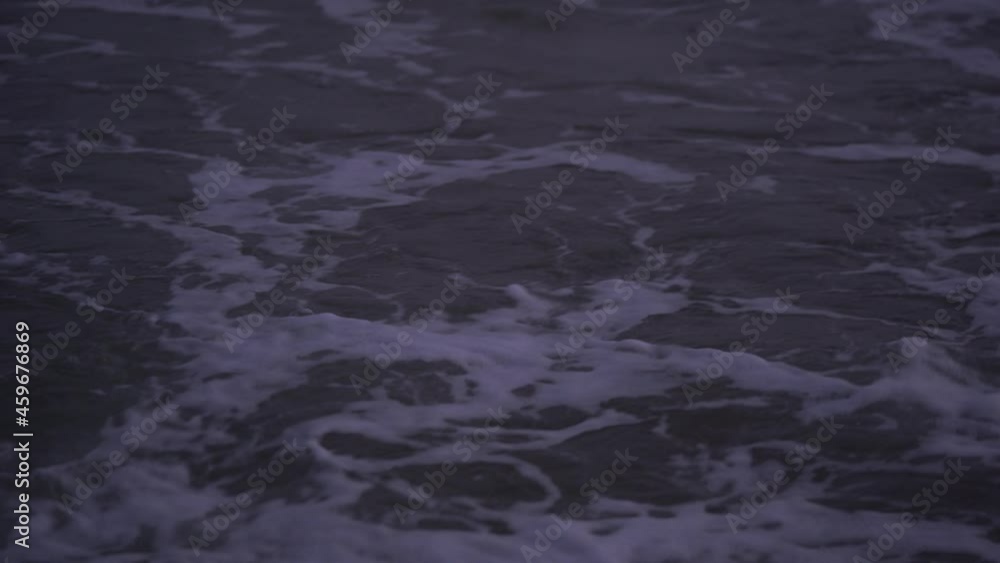 Close-up texture of sea waves and foam in the rays of the setting sun.Storming sea, ocean in the evening.Sea foam.Dark water.Beautiful natural video of the evening sea. Close-up texture of sea waves and foam in the rays of the setting sun.Storming sea, ocean in the evening.Sea foam.Dark water.Beautiful natural video of the evening sea.