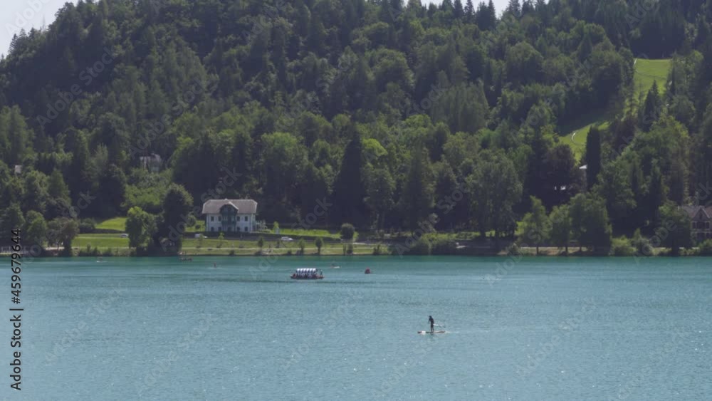 A Lone Stand-Up-Paddle-Boarder Paddling in Lake Bled, Slovenia A Lone Stand-Up-Paddle-Boarder Paddling in Lake Bled, Slovenia