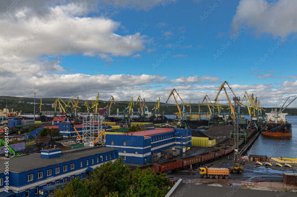 harbor cranes loading coal on bulk cargo ships at Murmansk port