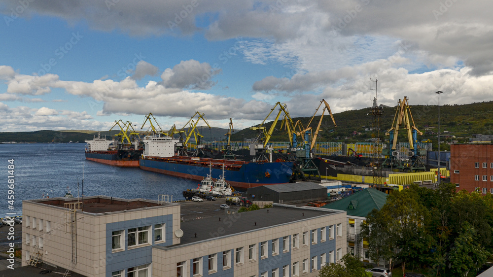 harbor cranes loading coal on bulk cargo ships at Murmansk port