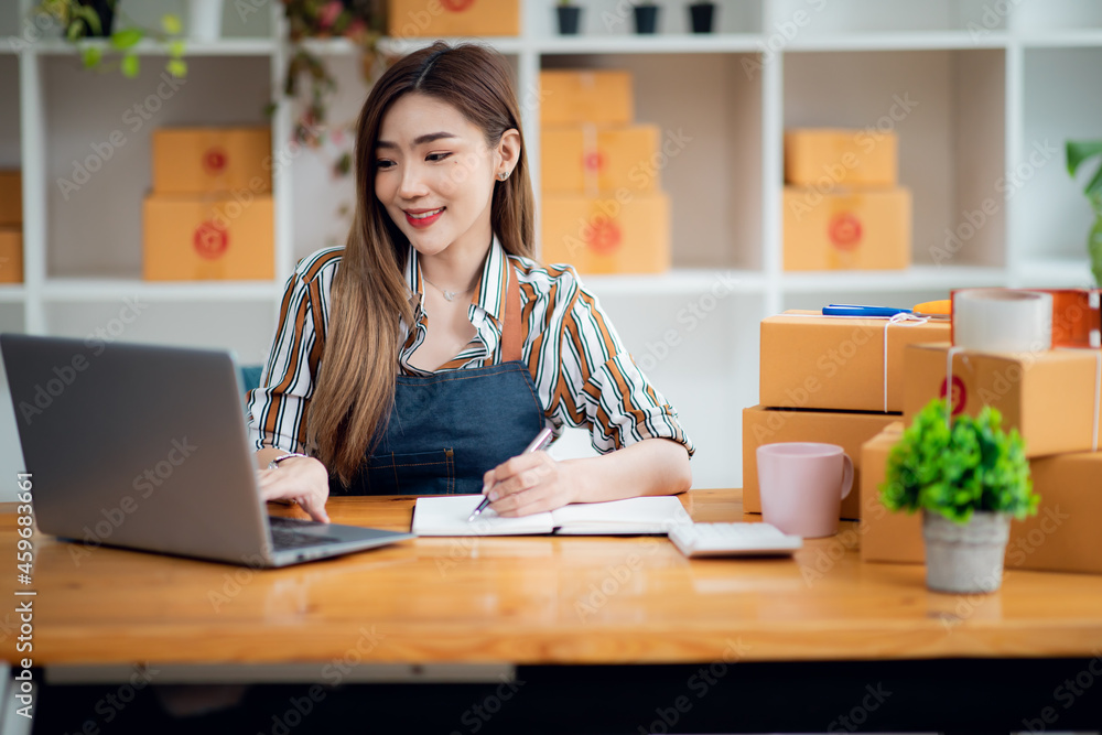 Portrait of Asian young woman SME working with a box at home the workplace.start-up small business owner, small business entrepreneur SME or freelance business online and delivery concept. Portrait of Asian young woman SME working with a box at home the workplace.start-up small business owner, small business entrepreneur SME or freelance business online and delivery concept.
