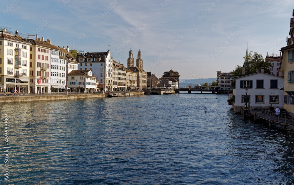 Zurich switzerland sept. 13 2021: view from the railroad station bridge to the limmat, grossmünster, rudolf brun bridge in the warm morning sun, blue sky, light clouds