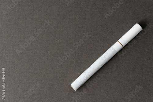 One cigarette on a gray background for a copy space.