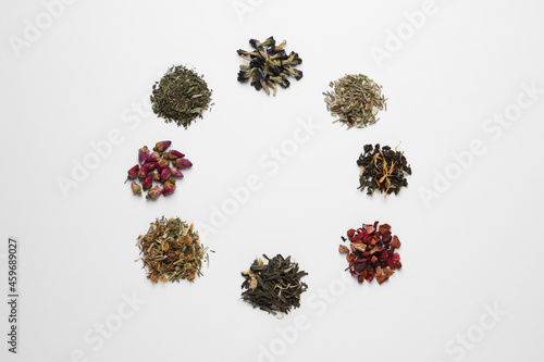 Frame of different dry teas on white background, top view