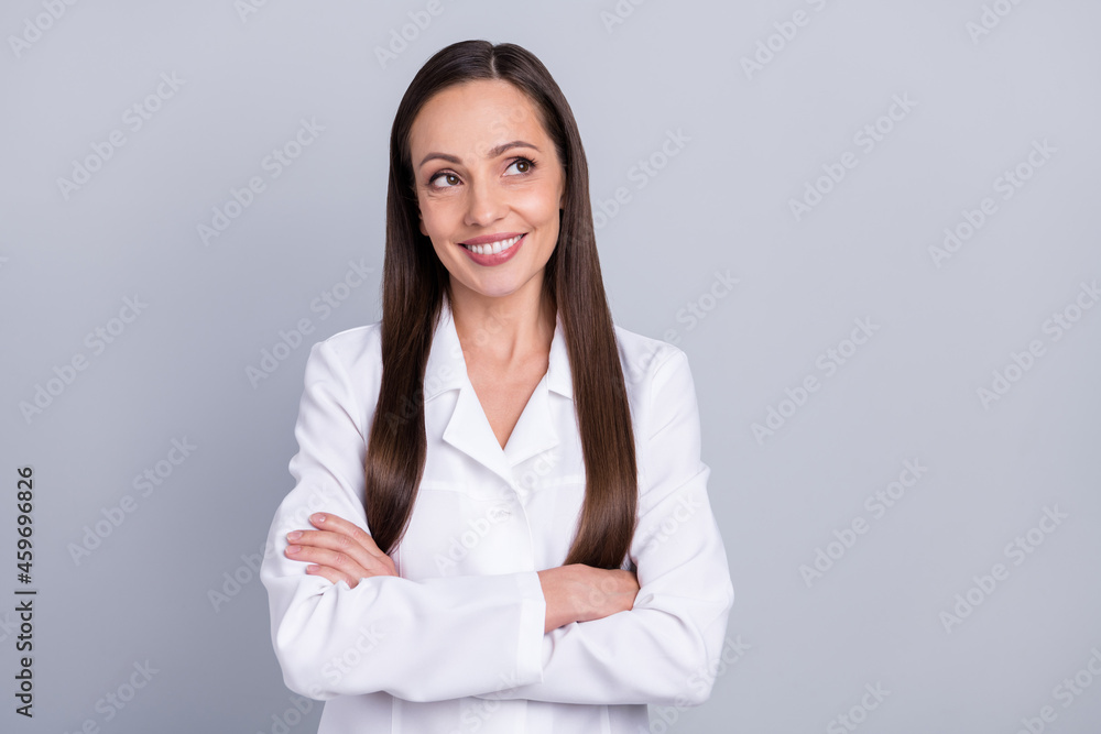 Photo of mature attractive woman happy positive smile crossed hands dream think look empty space isolated over grey color background Photo of mature attractive woman happy positive smile crossed hands dream think look empty space isolated over grey color background