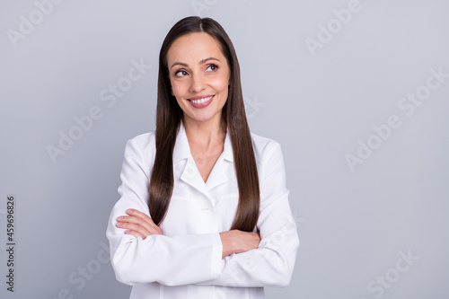 Photo of mature attractive woman happy positive smile crossed hands dream think look empty space isolated over grey color background