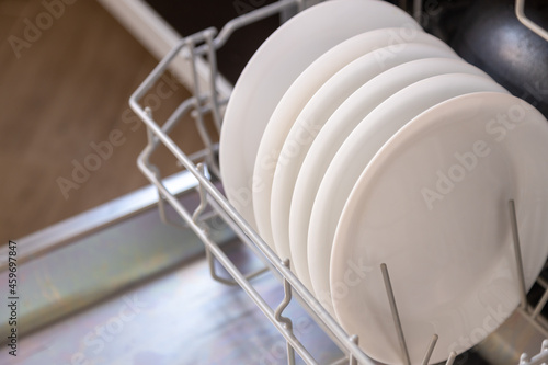 white dishes in the dishwasher, open door