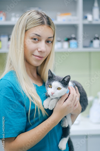 Portrait of a beautiful female veterinarian holding a cat in an animal hospital