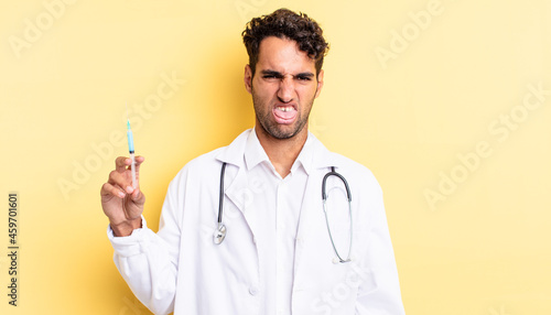hispanic handsome man feeling disgusted and irritated and tongue out physician and srynge concept photo