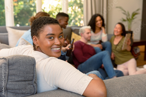 Happy african american woman having fun with diverse group of female and male friends at home