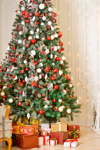 christmas, christmas tree on the background of a fireplace with toys and a retro sofa, holiday gifts © Зоя Мельнийчук