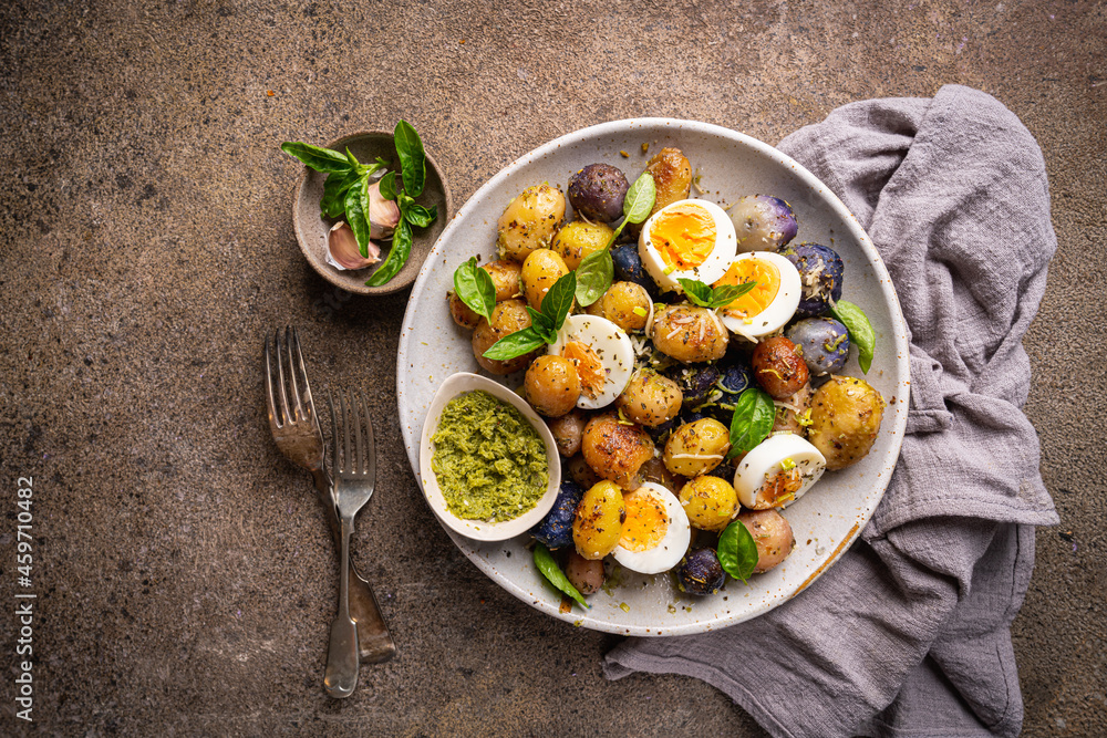 Homemade salad of new colorful potatoes, quail eggs and pesto, top view Homemade salad of new colorful potatoes, quail eggs and pesto, top view