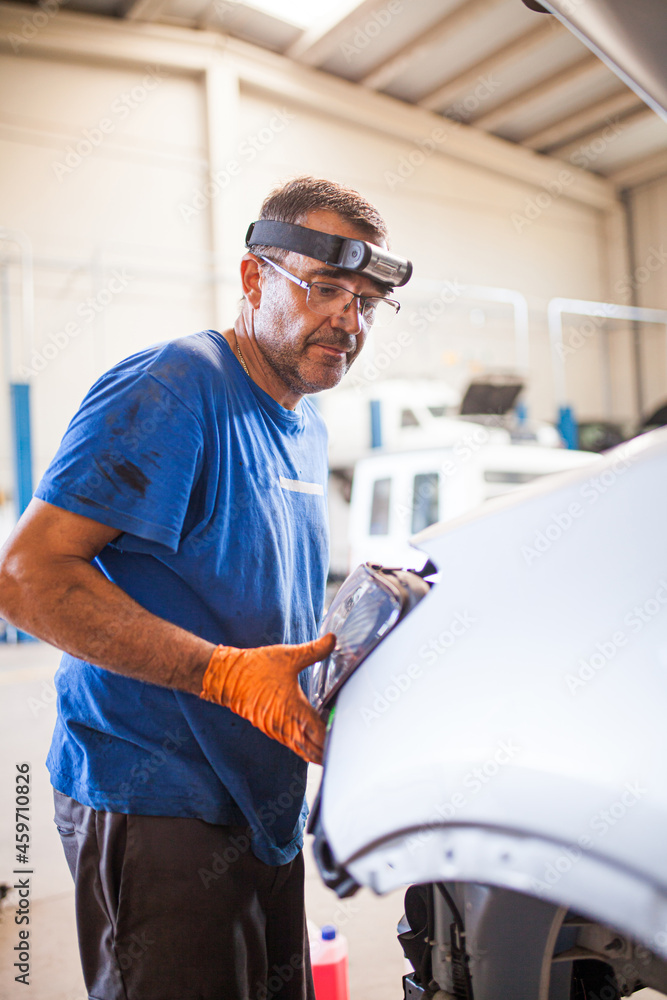 Busy mechanic repairing car in service Busy mechanic repairing car in service