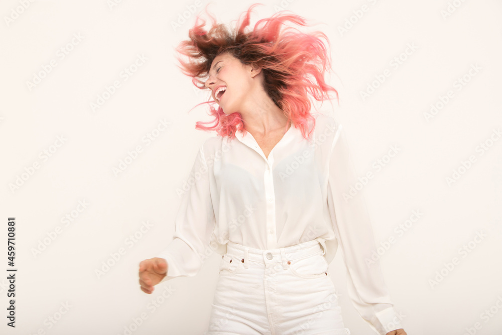 Happy woman shaking hair in light studio