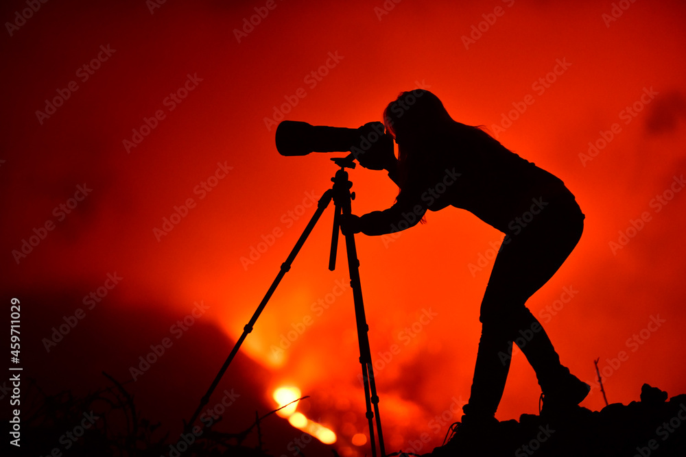 Woman silhouette of a photographer and in the background a lava explosion in La Palma Canary Islands 2021 Woman silhouette of a photographer and in the background a lava explosion in La Palma Canary Islands 2021