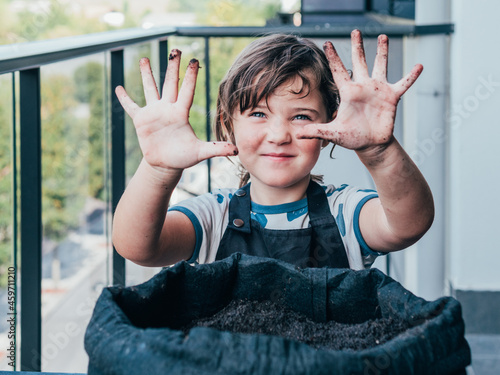 Girl showing dirty hands and looking at camera
