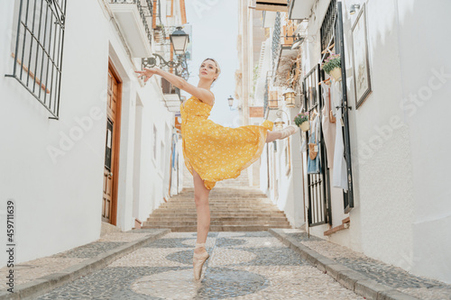 Graceful ballerina standing on tiptoe and raising leg photo