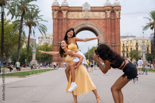 Canvas Print Cheerful women taking photo on city square
