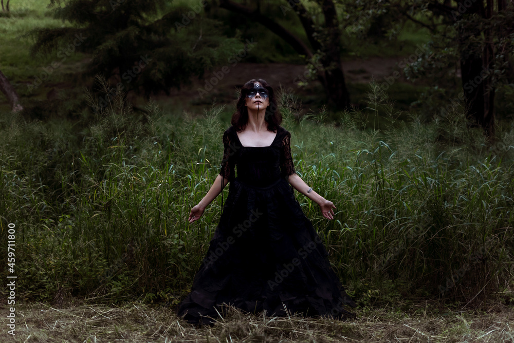 Witch in black dress in dark forest Witch in black dress in dark forest