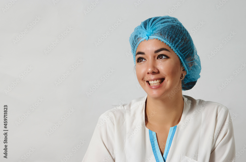 Smiling female doctor in lab coat and hat on white background Smiling female doctor in lab coat and hat on white background