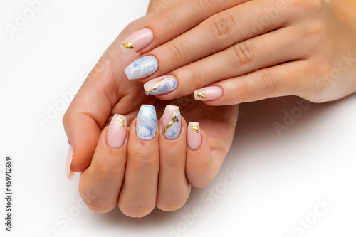 Bolero nail shape. Nude, natural manicure with blue, white veins and gold foil on long nails. Gel nails. Heavenly manicure. Close-up on a white background.