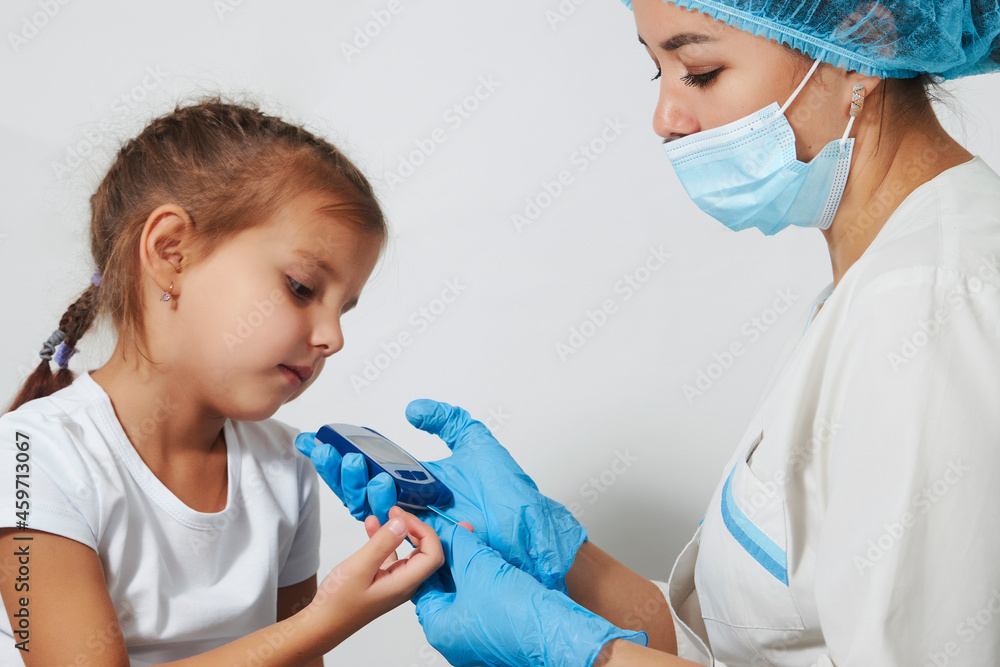 Young nurse doctor measuring blood sugar level of girl Young nurse doctor measuring blood sugar level of girl