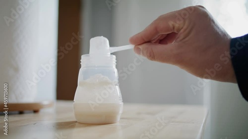 Man Father Prepares Baby Formula with Bottle In Clean Kitchen for Toddler Infant
