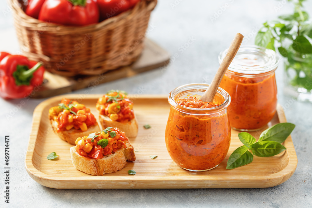 Ajvar (pepper mousse) in a jar and on a slices of bread Ajvar (pepper mousse) in a jar and on a slices of bread