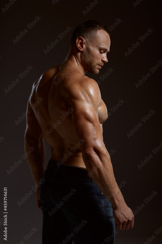 Fototapeta premium Male athlete with muscular body poses in studio
