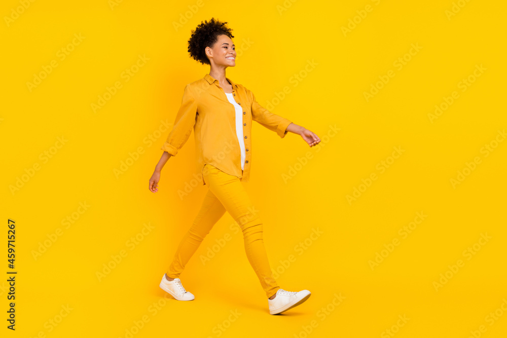 Full length body size photo woman smiling wslking forward isolated bright yellow color background