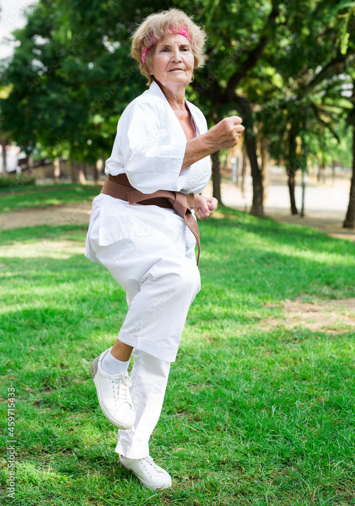 Old lady exercising karate in park