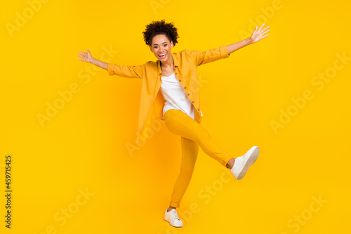 Full length body size photo woman laughing dancing at disco isolated vivid yellow color background