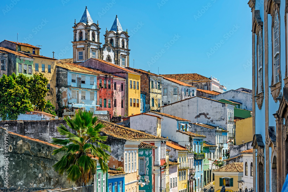 Colorful houses facades and historic church towers in baroque and colonial style with blue sky in the famous Pelourinho neighborhood of Salvador, Bahia