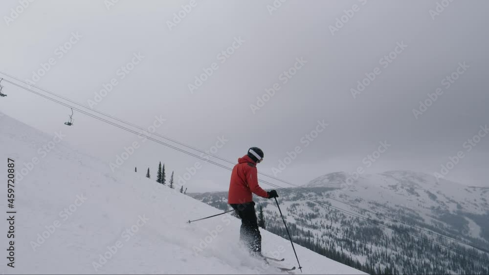 Professional Skier Skiing Down A Steep Snowy Slope In Mountains At Ski Resort Professional Skier Skiing Down A Steep Snowy Slope In Mountains At Ski Resort