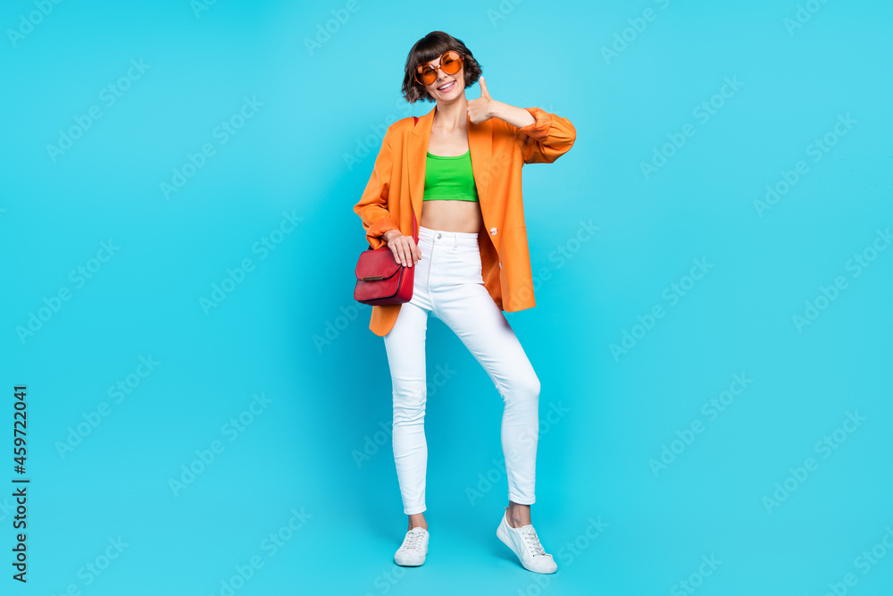 Full size photo of happy young woman wear bag sunglass make thumb-up isolated on blue color background