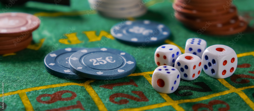 Gambling board game.Cards, chips, roulette.Gaming flat lay. Close-up of a card for playing poker on a gaming table in a casino against a background of chips. Background for the gaming business.