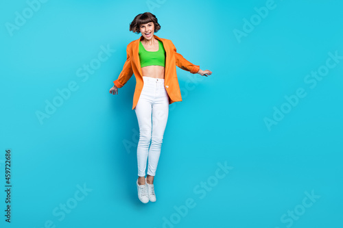 Fototapeta Naklejka Na Ścianę i Meble -  Full body photo of happy cheerful woman jump up good mood weekend dream isolated on blue color background