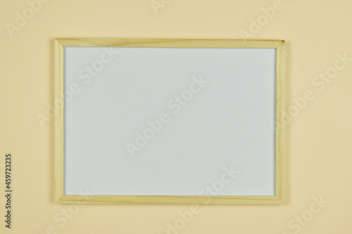 Whiteboard with wooden frame on orange background with copy space.
