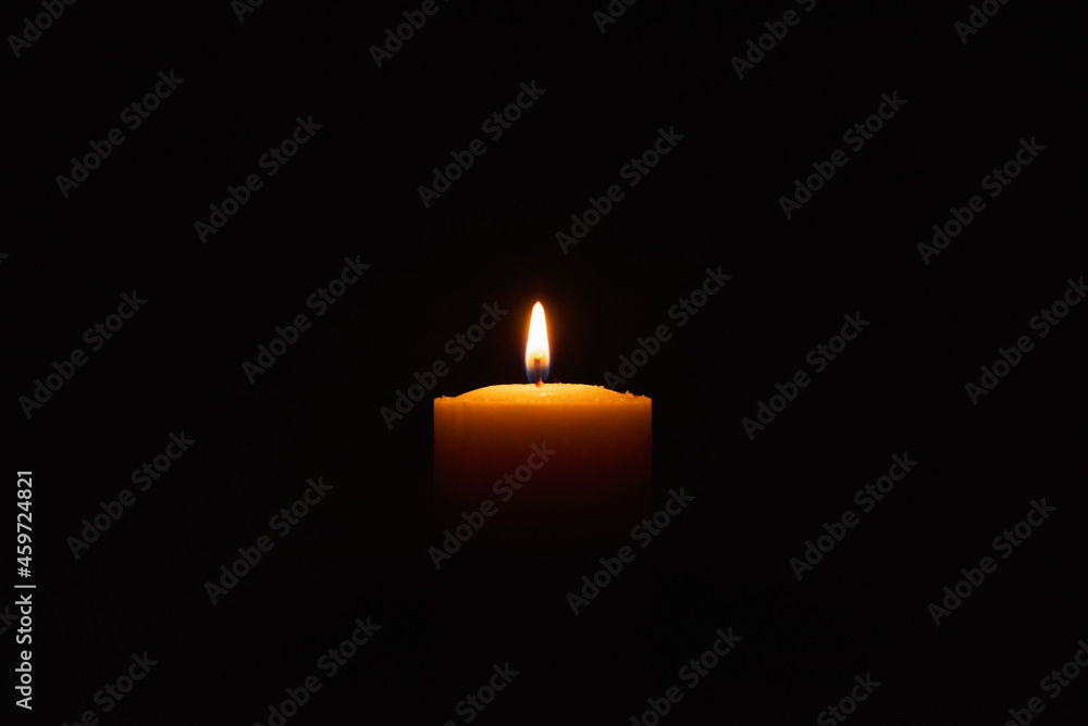 One single light candle burning brightly in the black background.Spiritual candle yellow flame. Flame of candle in the darkness.Copy space. One single light candle burning brightly in the black background.Spiritual candle yellow flame. Flame of candle in the darkness.Copy space.
